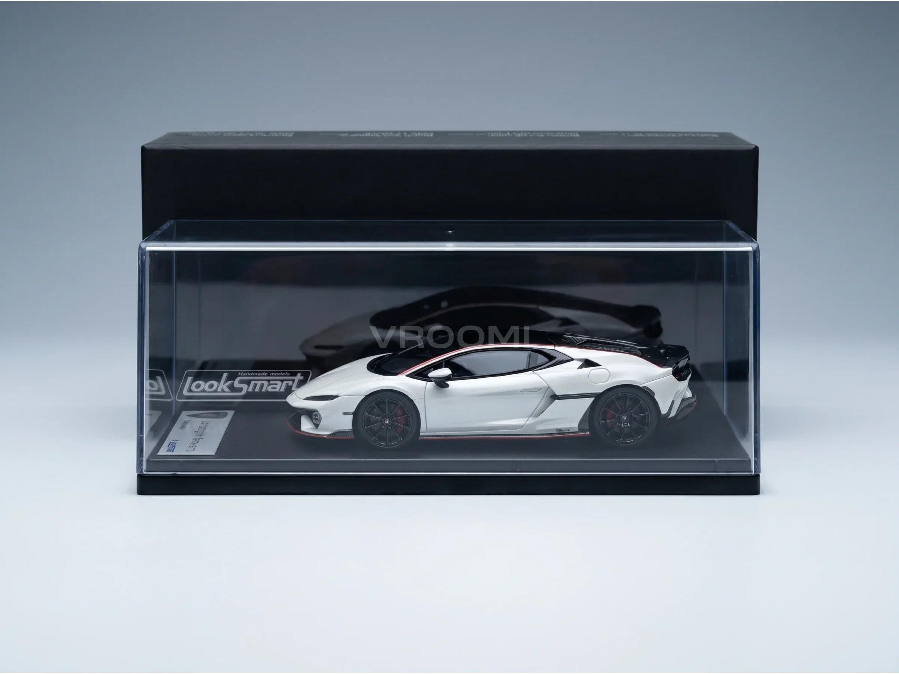 Wit schaalmodel van een Lamborghini Huracán in een doorzichtige vitrine van LookSmart, samengesteld door Vroomi voor verzamelaars.