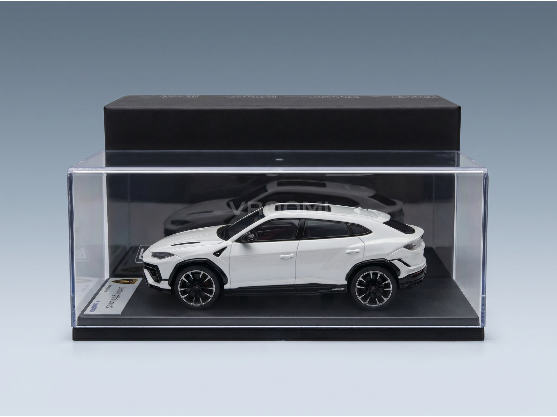 Maquette de Lamborghini Urus blanche dans une vitrine transparente, objet de collection haut de gamme de la marque Vroomi