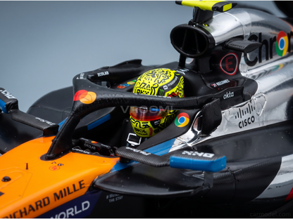 Casque de course jaune avec graffitis noirs et logo Google Chrome dans le cockpit de la McLaren F1 MCL39 argent et orange