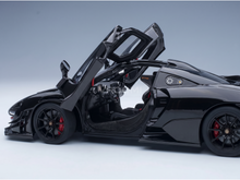 Black scale model car with open doors, detailed interior, and carbon fiber accents at Vroomi