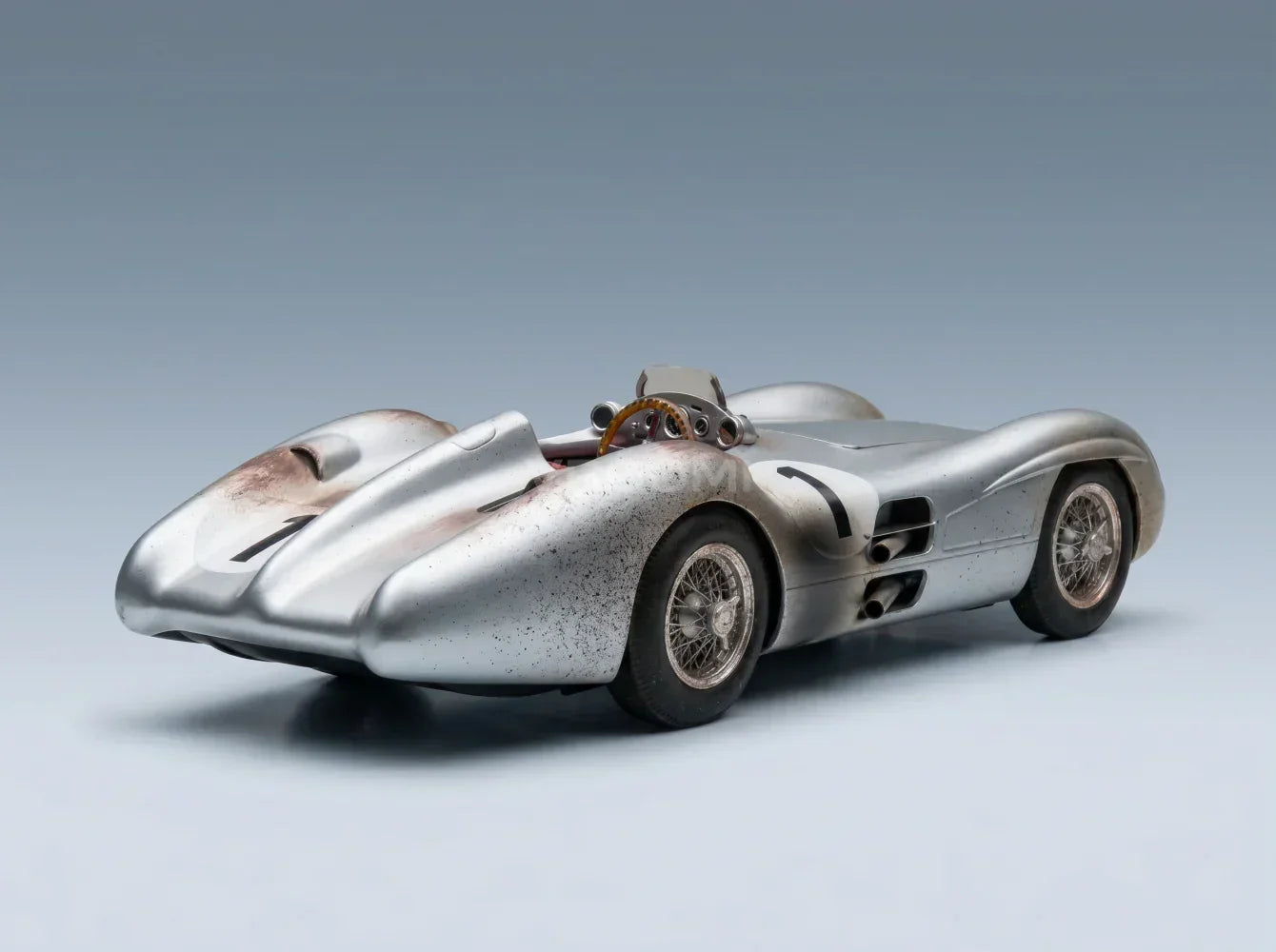 MERCEDES BENZ - F1 W196R STREAMLINERS N.º 1: POLE POSITION 4.º GP DE GRAN BRETAÑA (VERSIÓN «SUCIA») JUAN MANUEL FANGIO, CAMPEÓN DEL MUNDO DE 1954 - CON VITRINA - Vroomi: Tienda de maquetas de coches a escala