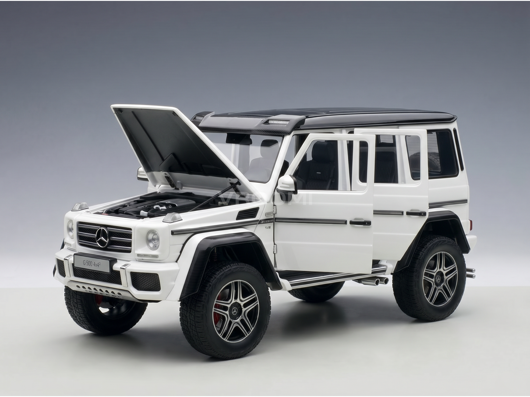 White Mercedes-Benz G500 4x4² scale model car with open hood and doors, showcased by Vroomi