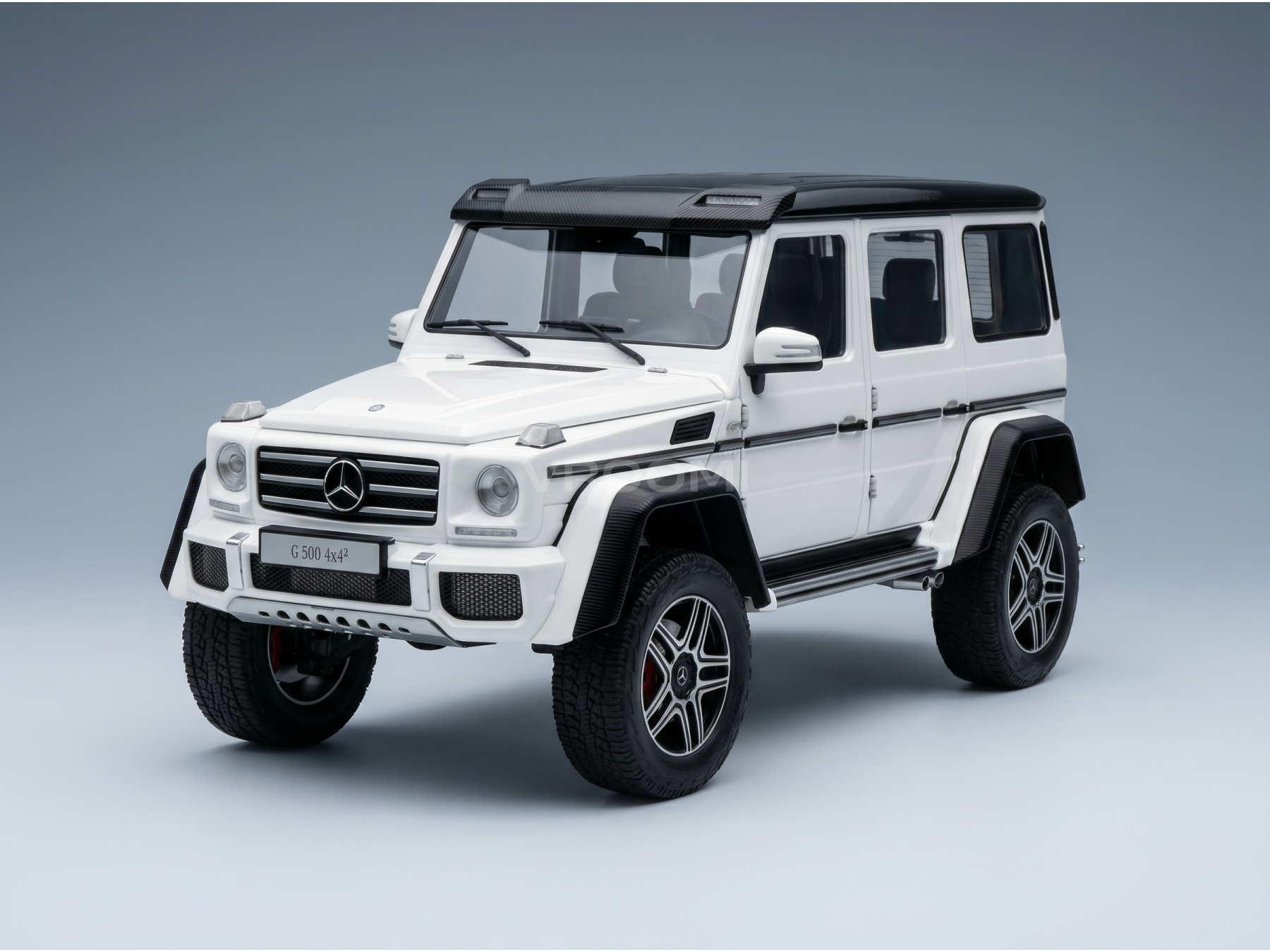 White Mercedes-Benz G 500 4x4² scale model car with black accents, showcased by Vroomi for collectors.