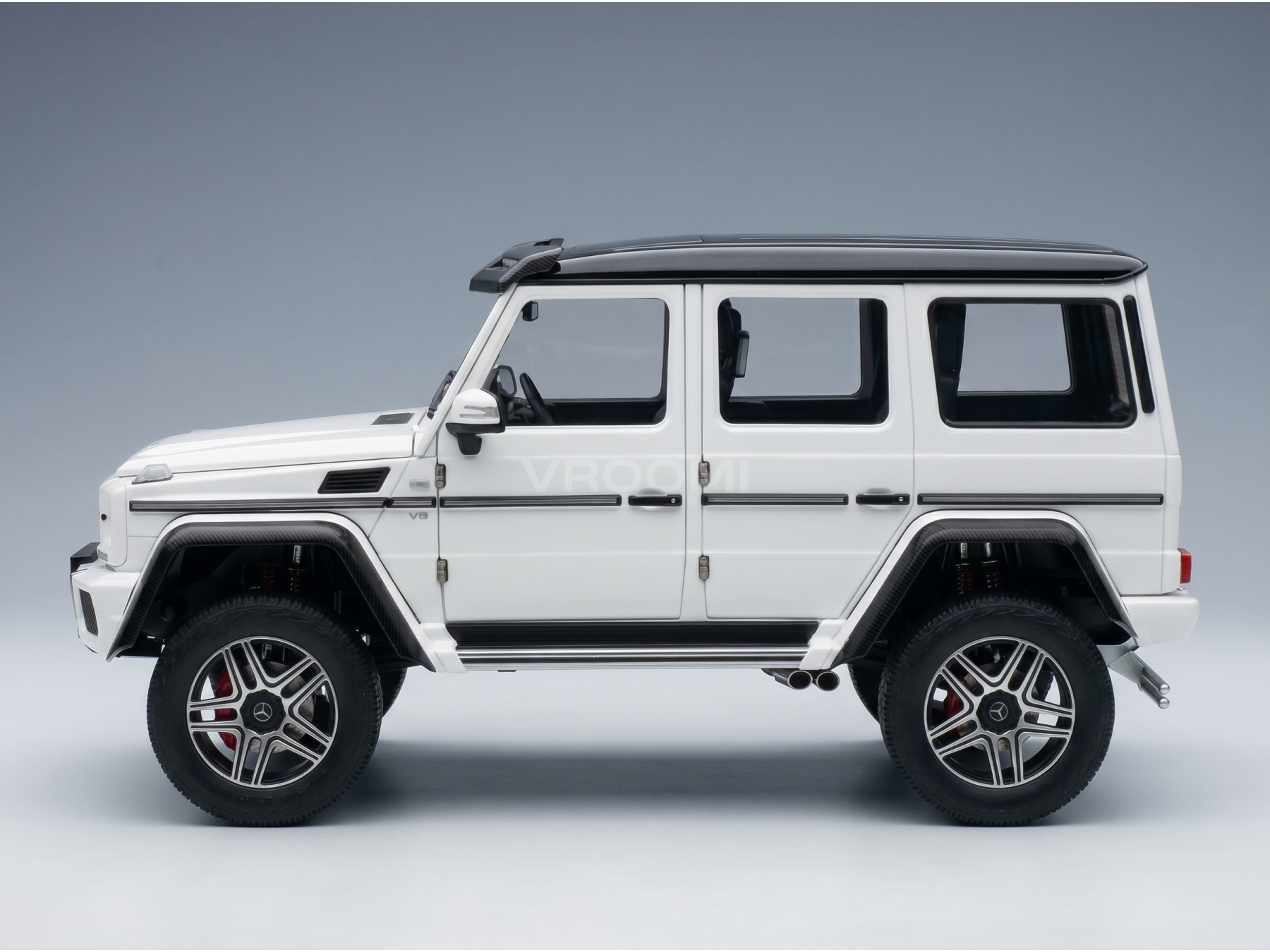 White Mercedes-Benz G-Wagon scale model car with black roof and alloy wheels, showcased by Vroomi