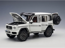 Maqueta a escala de un Mercedes-Benz G-Wagen blanco con las puertas y el capó abiertos, presentada por Vroomi