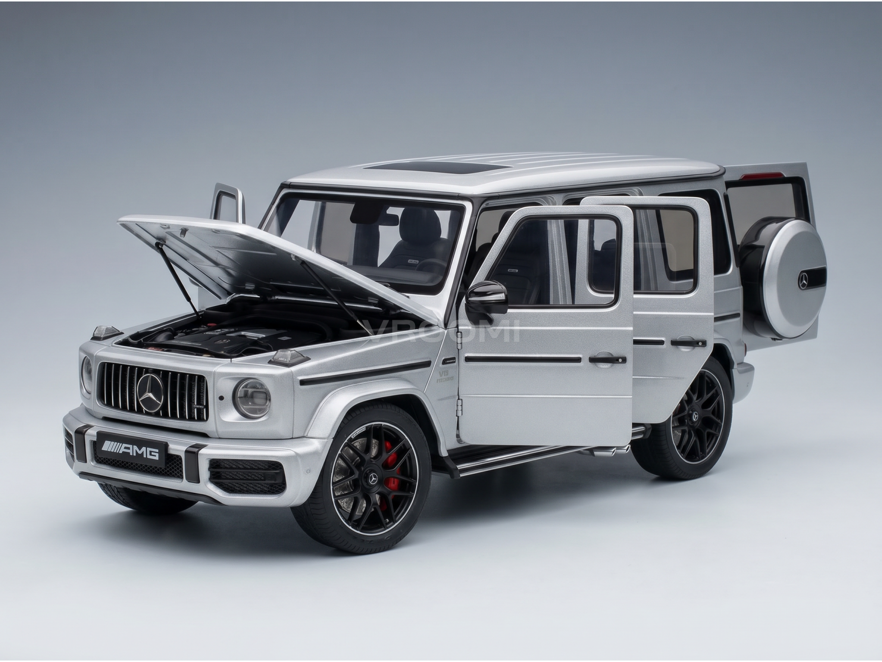 Zilverkleurig Mercedes-AMG G63-schaalmodel met open deuren en motorkap, gedetailleerde motor, bij Vroomi