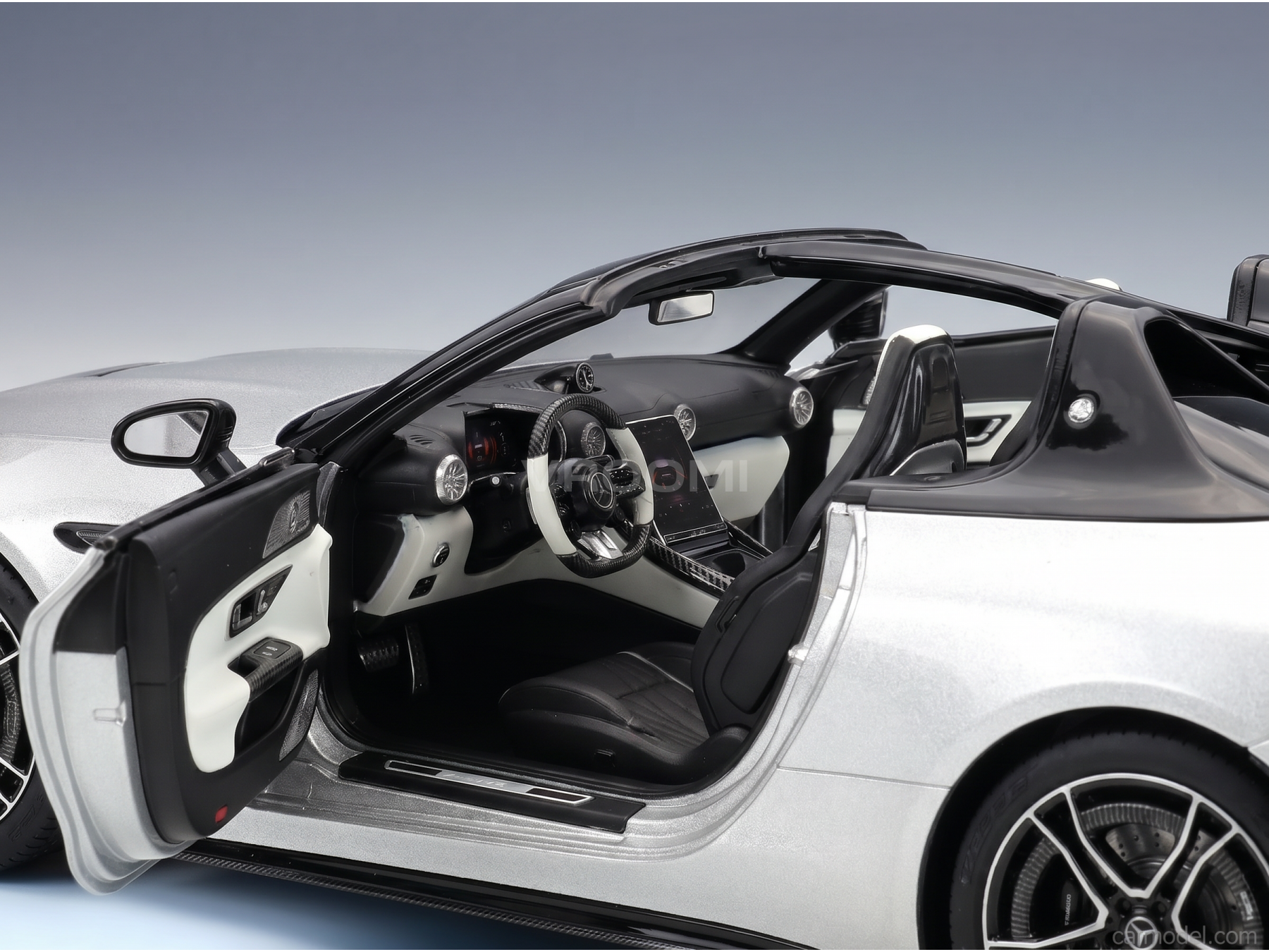 Silver scale model car with open doors, detailed interior, and sleek design from Vroomi
