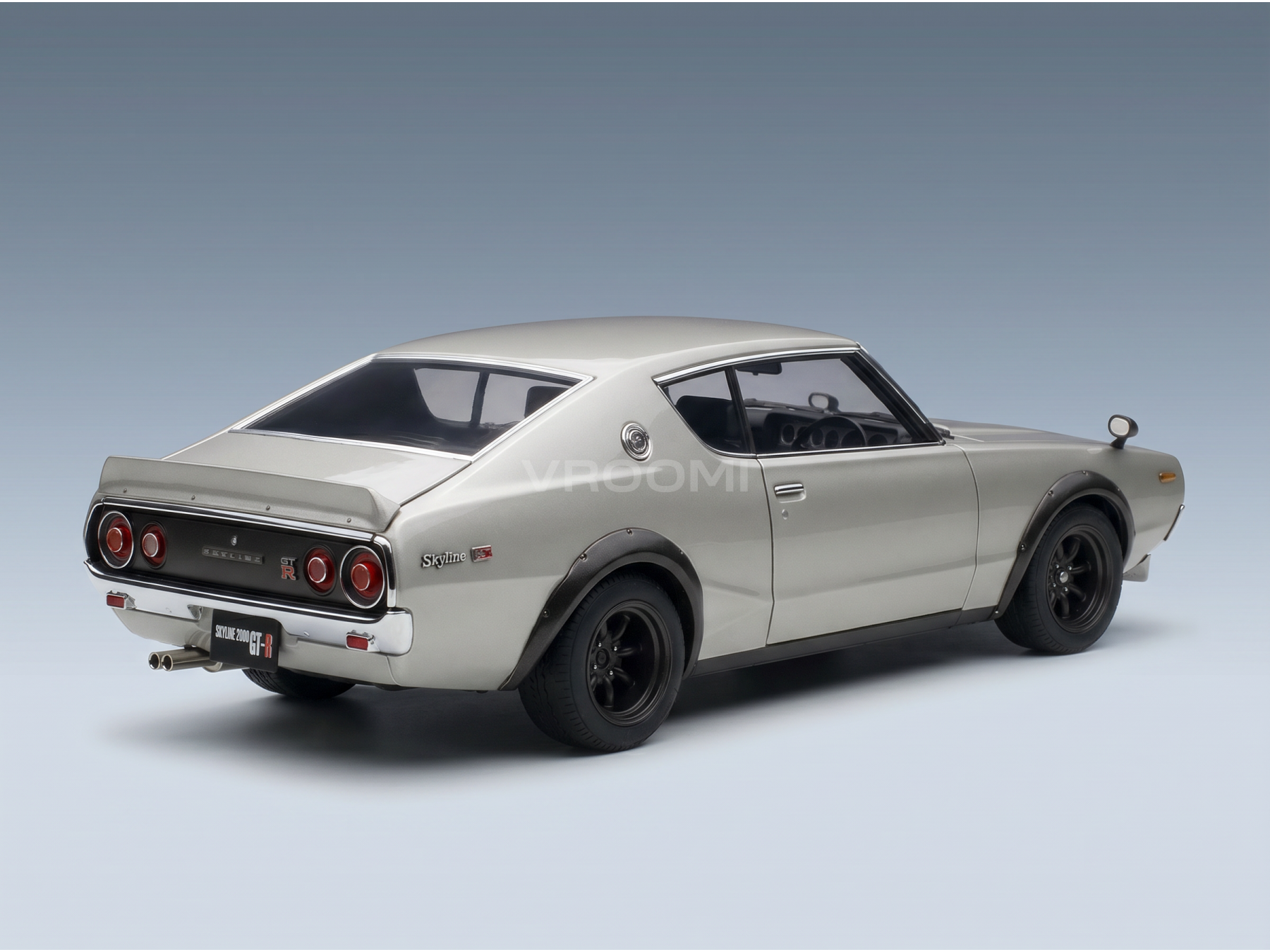 Maqueta a escala de un Nissan Skyline 2000 GT-R plateado de la marca Vroomi, con llantas negras y un diseño trasero clásico.