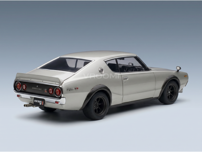 Maqueta a escala de un Nissan Skyline 2000 GT-R plateado de la marca Vroomi, con llantas negras y un diseño trasero clásico.