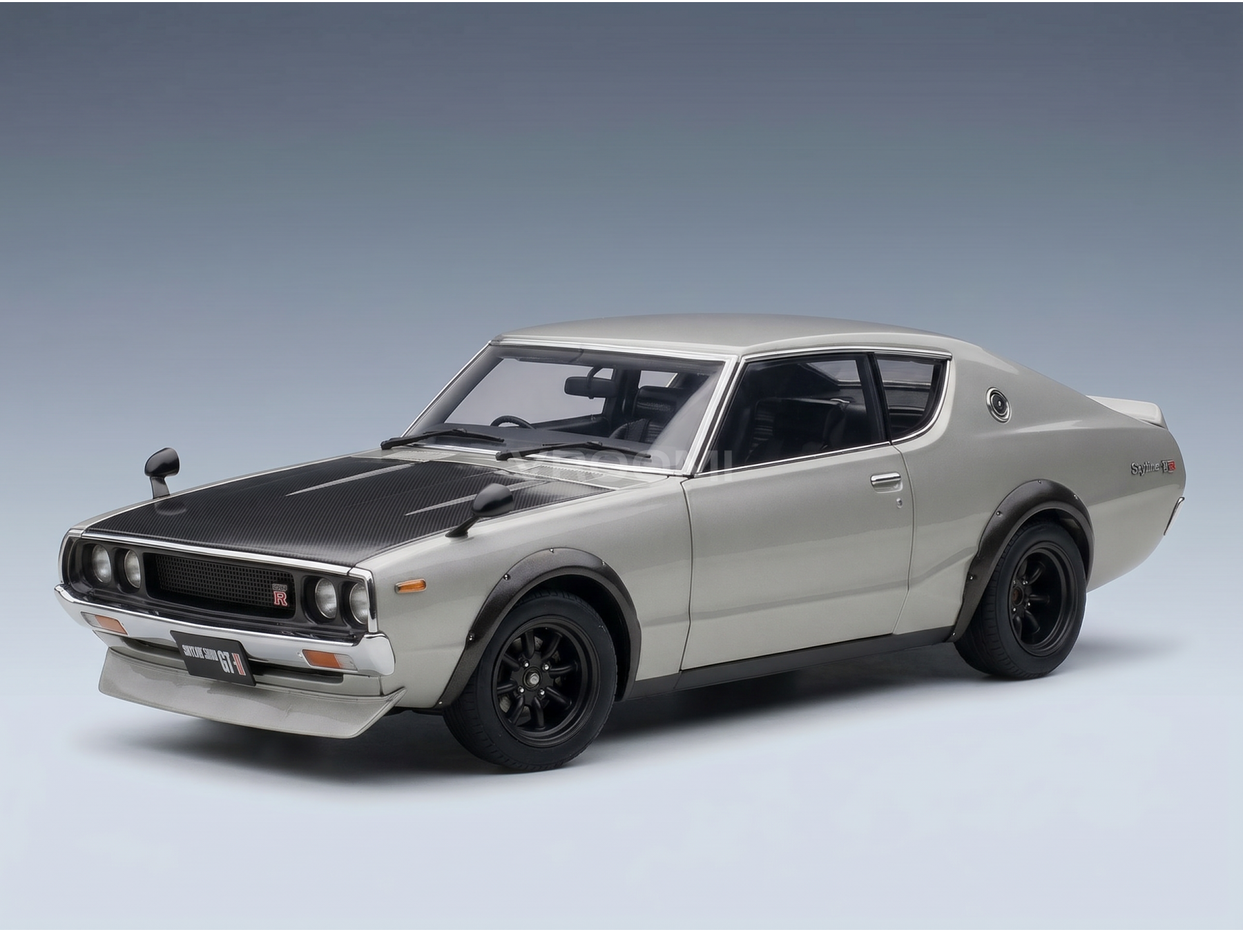 Maquette de voiture argentée rehaussée de touches noires, présentée par Vroomi à l'intention des collectionneurs et des passionnés de sport automobile.