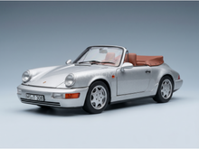 Zilverkleurig schaalmodel van een Porsche 911 cabriolet met een beige interieur, gepresenteerd door Vroomi voor verzamelaars.