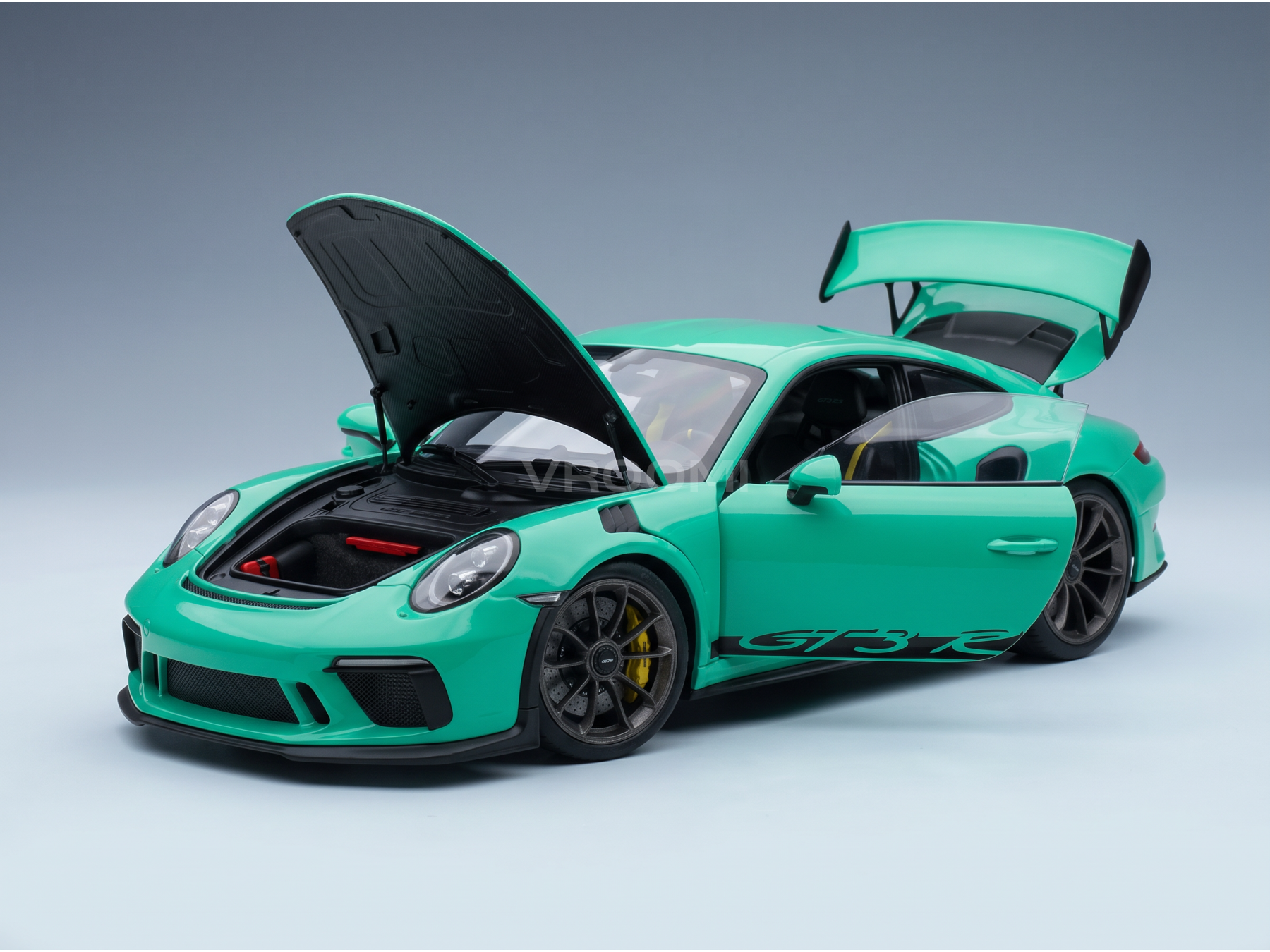 Vroomi scale model car: mint green Porsche GT3 RS with open hood, doors, and rear wing, detailed interior and wheels.