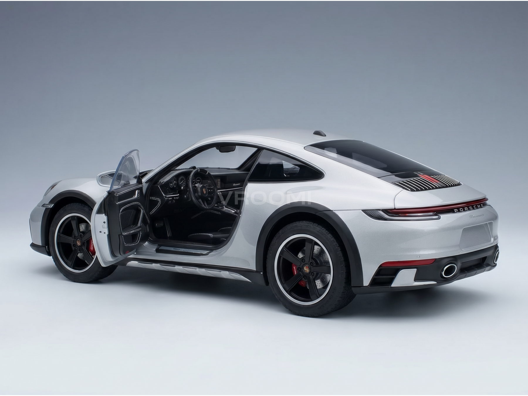 Silver Porsche scale model car with open door, detailed interior, at Vroomi