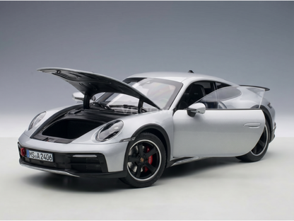 Silver Porsche scale model car with open hood, detailed engine, and black rims at Vroomi