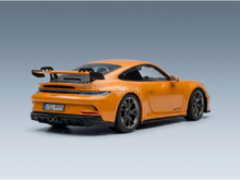Maqueta a escala de un Porsche GT3 de color naranja de la marca Vroomi, que destaca por su elegante diseño y su alerón trasero