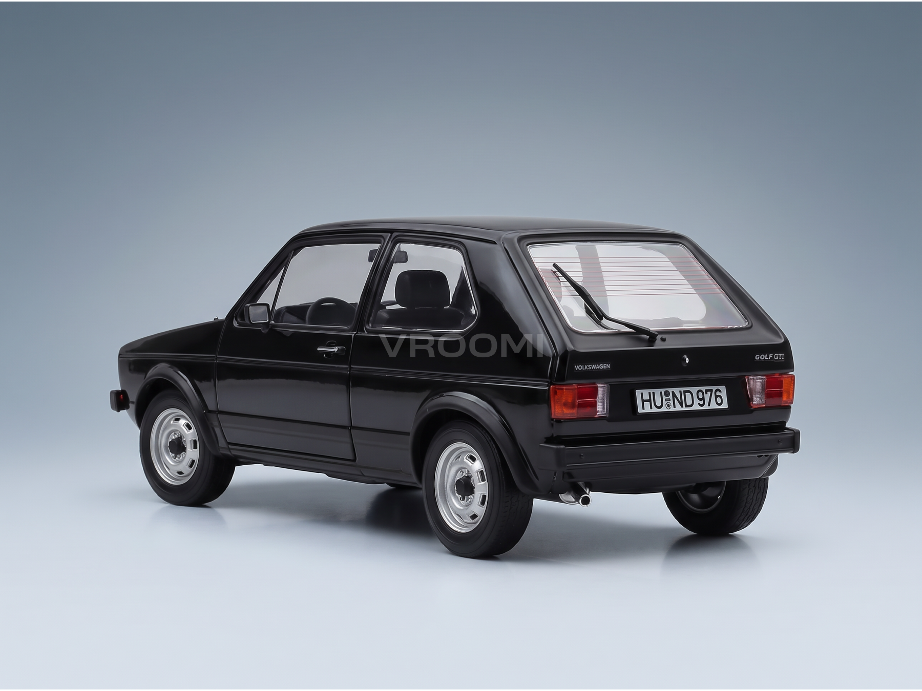Zwart schaalmodel van de Volkswagen Golf GTI van Vroomi, met het klassieke ontwerp uit de jaren 80 en een gedetailleerd achteraanzicht.