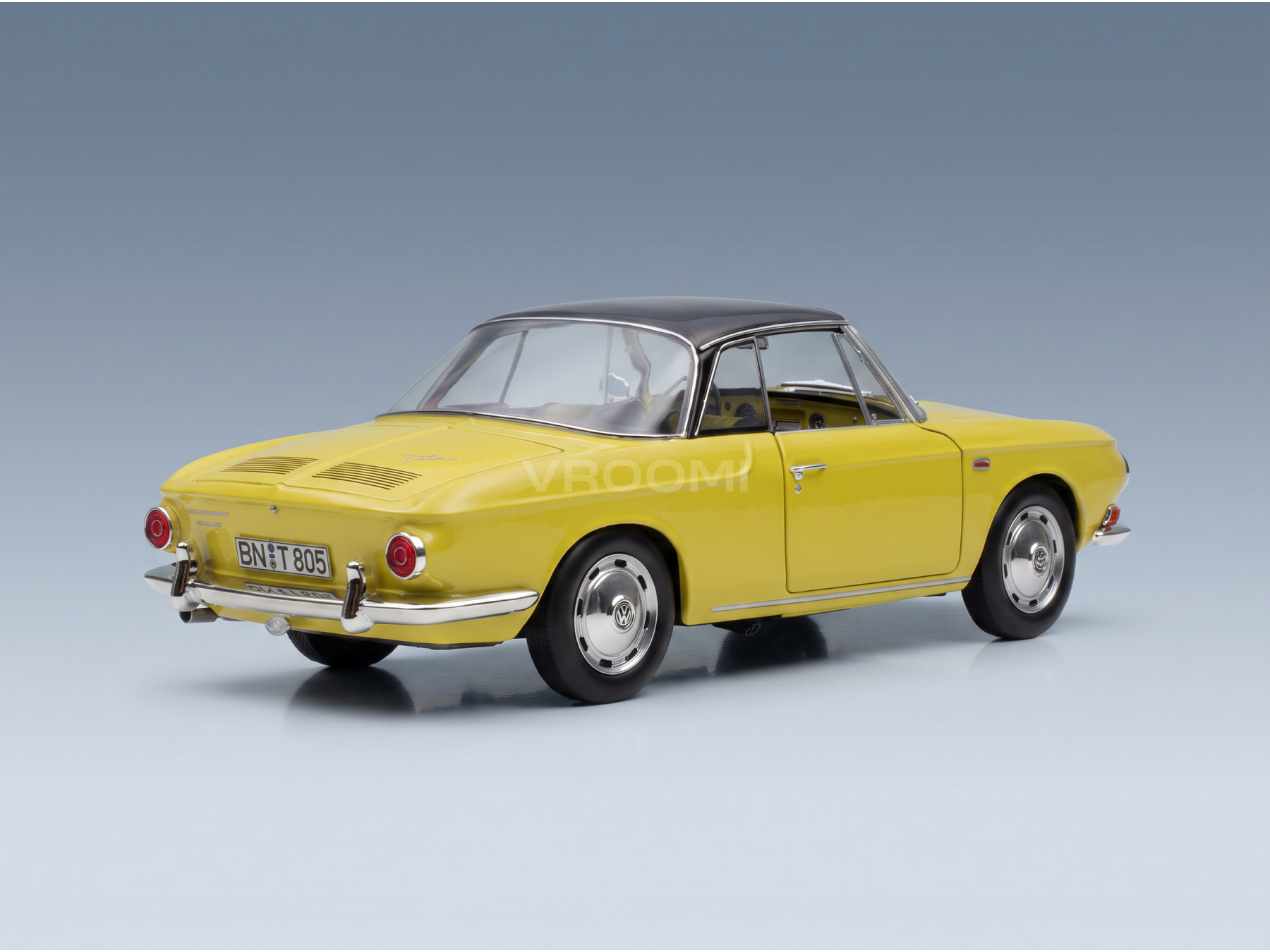 Geel Volkswagen Karmann Ghia-schaalmodel van Vroomi, klassiek ontwerp uit de jaren ’60 met zwart dak en chromen details