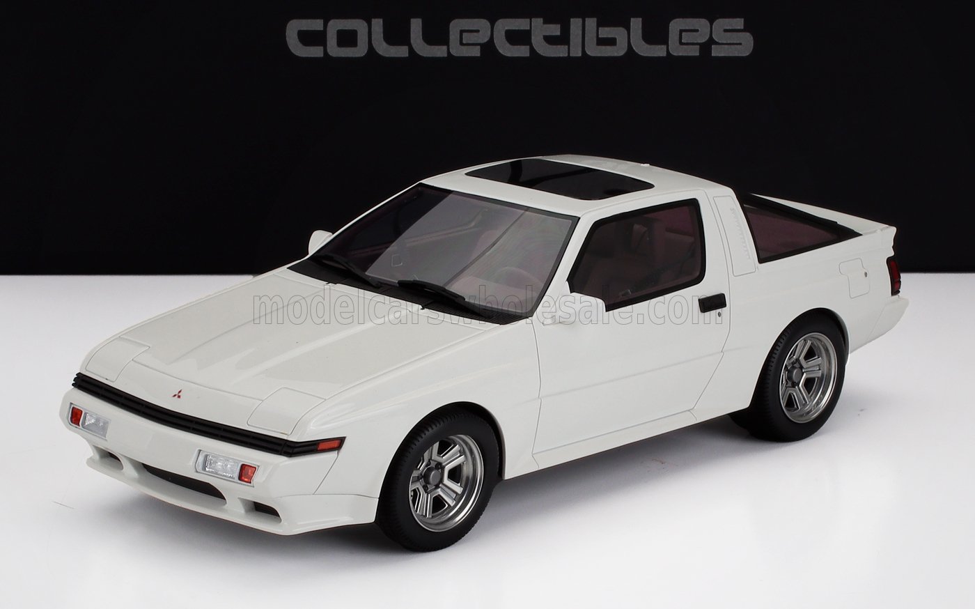 White Mitsubishi Starion vintage sports car model displayed against black and white backdrop, available on Vroomi