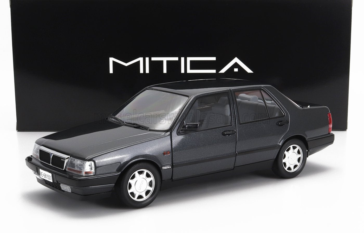 Coche modelo Lancia Thema gris metalizado oscuro con llantas plateadas, expuesto con caja Mitica, disponible en Vroomi.