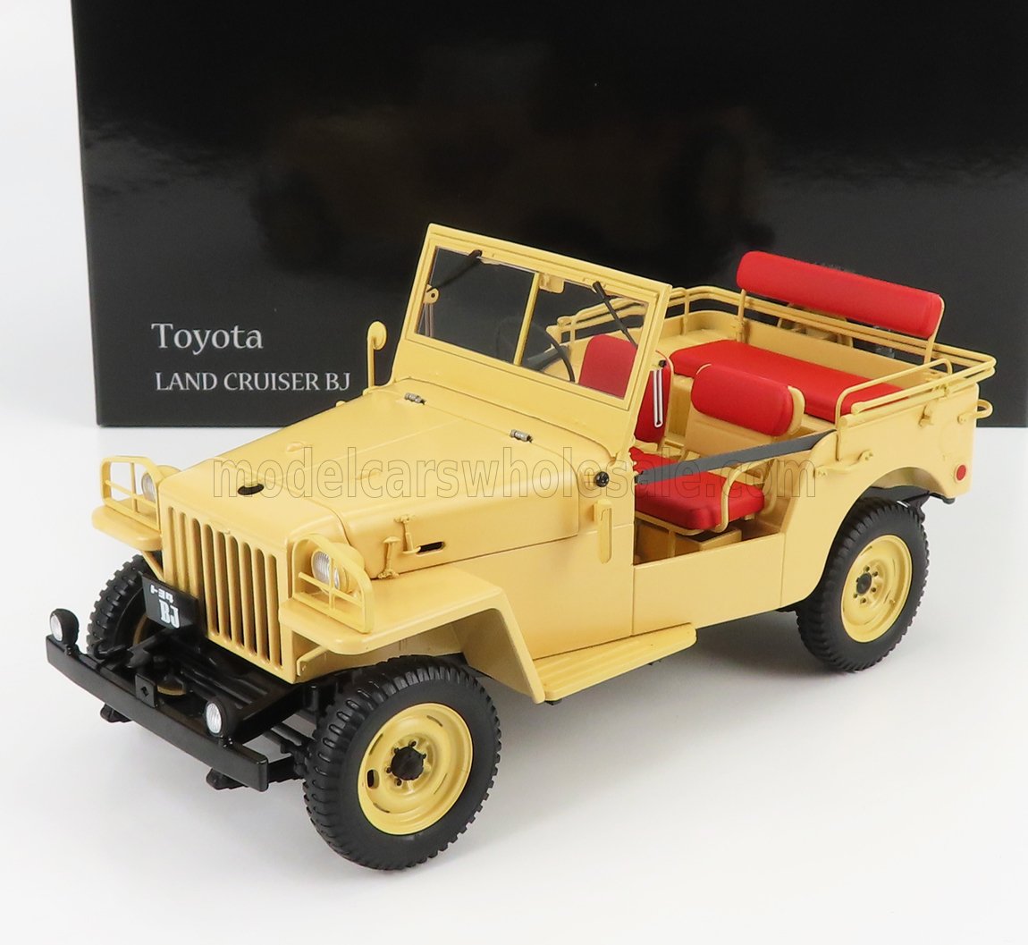Toyota Land Cruiser BJ amarillo con asientos rojos expuesto delante de una caja negra, disponible a través de Vroomi.