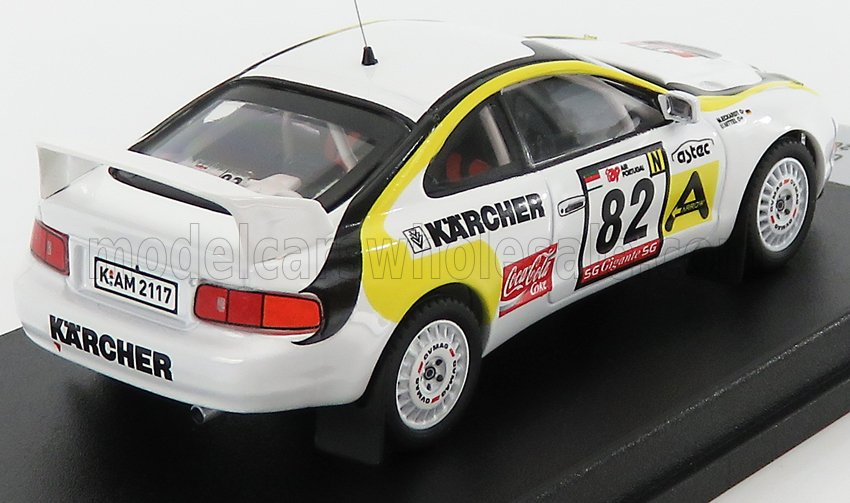 Modelo de coche de rally Toyota a escala 1/18 con adhesivos de carreras, blanco y amarillo, disponible para coleccionistas en Vroomi.