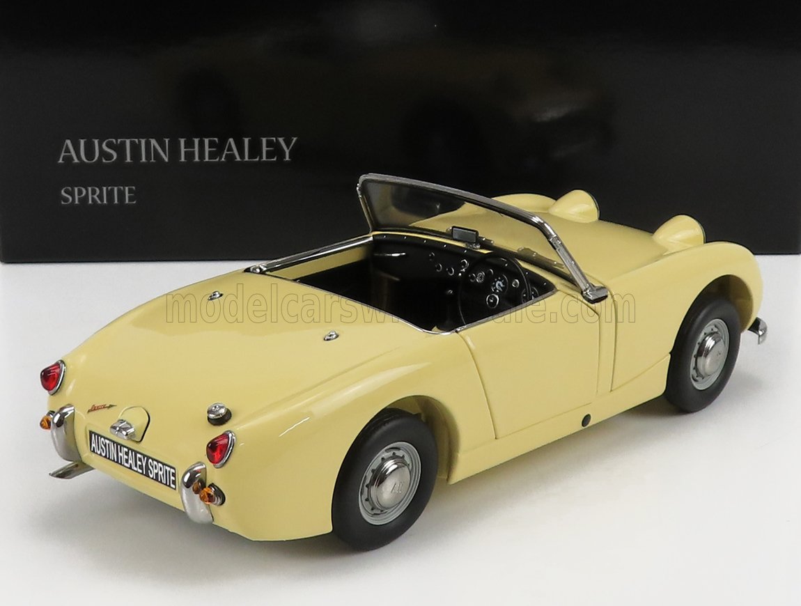 Modelo de coche descapotable Austin Healey Sprite amarillo expuesto sobre una superficie blanca, presentado en Vroomi.