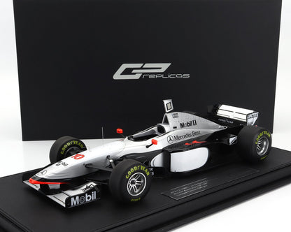 Modelo de coche de Fórmula 1 McLaren MP4/12 a escala 1:18 con neumáticos Goodyear y patrocinador Mobil, disponible en Vroomi.