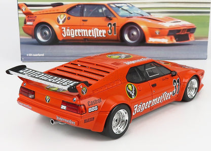 Modelo de coche de carreras BMW naranja Jägermeister con adhesivos y alerón, disponible a través de Vroomi.
