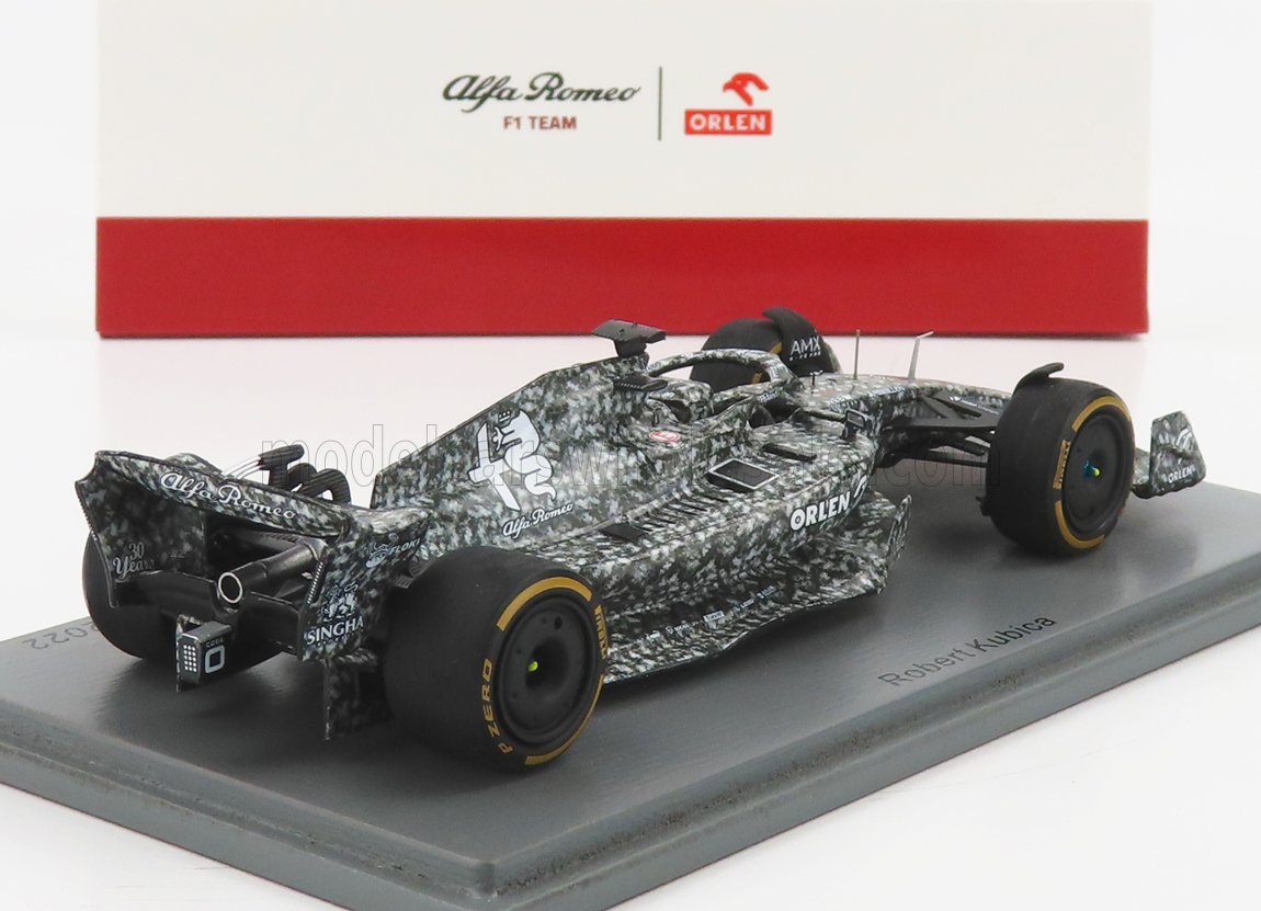 Modelo de coche Alfa Romeo F1 Team con diseño camuflado expuesto sobre una base, presentado en la plataforma Vroomi.