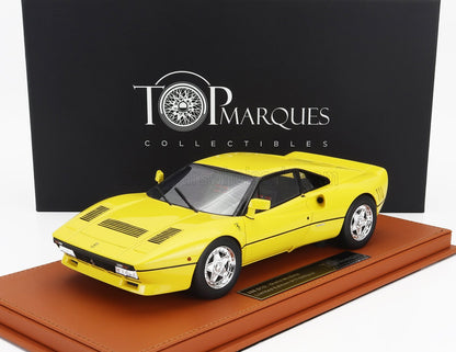 Maqueta a escala de un Ferrari 288 GTO amarillo sobre una base marrón con caja Top Marques Collectibles, disponible en Vroomi.