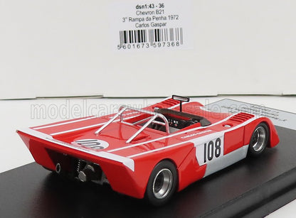 Coche de carreras modelo Red Chevron B21 con el número 108, jaula antivuelco detallada, expuesto sobre una plataforma negra, disponible en Vroomi.