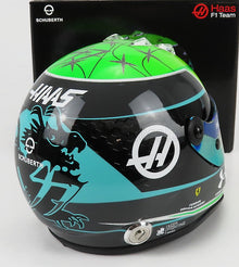 Casco de carreras Schuberth verde y negro con los logotipos del equipo Haas F1 y la Ferrari Driver Academy, disponible en Vroomi.