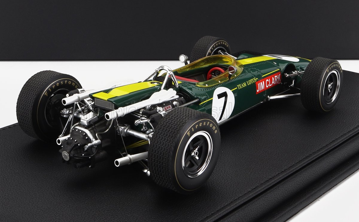 Modelo clásico del coche de carreras Team Lotus con los colores de Jim Clark, verde y amarillo, expuesto sobre una base negra, disponible a través de Vroomi.