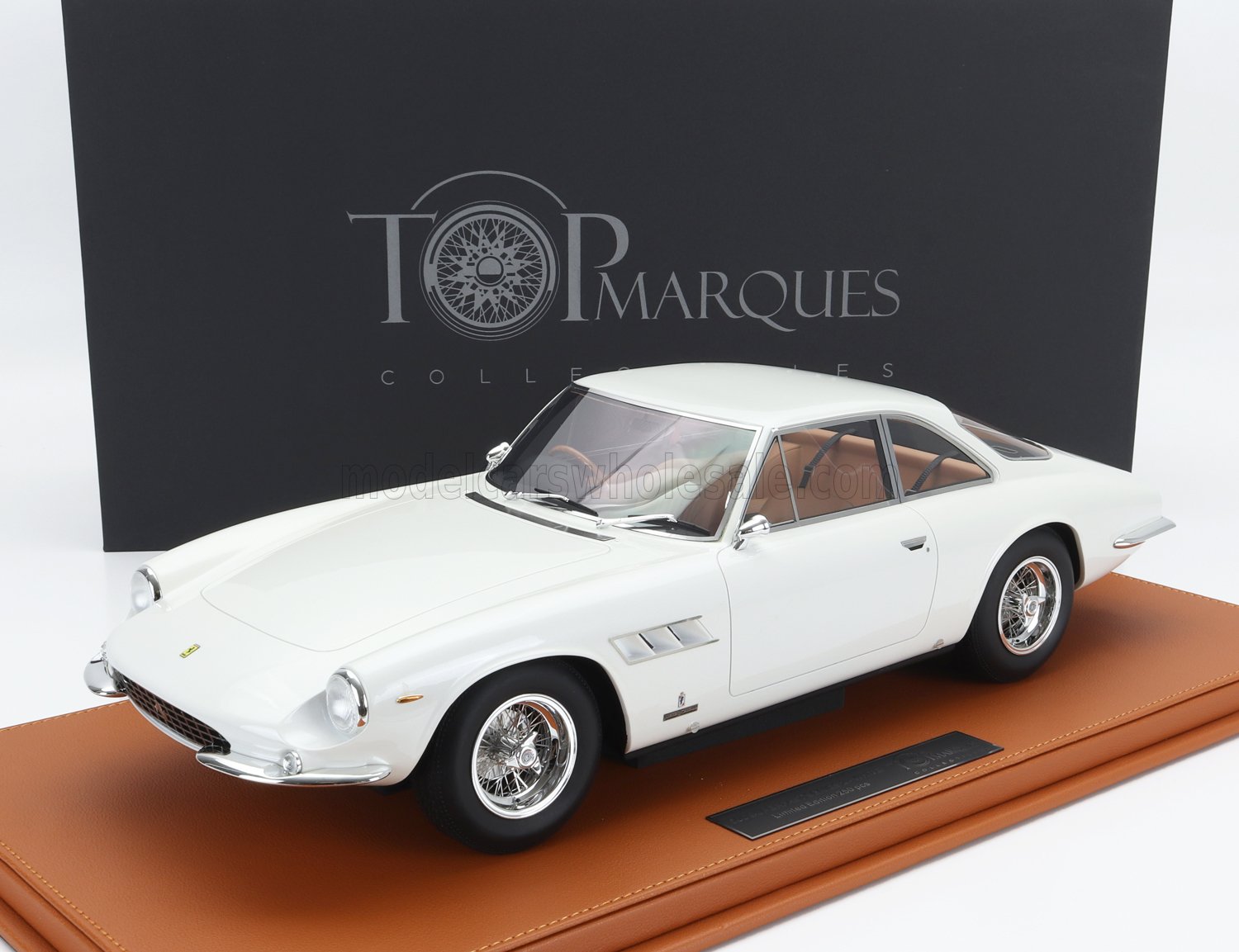 Modelo clásico de Ferrari blanco sobre una base de cuero marrón con fondo de Top Marques Collectibles, presentado en Vroomi.