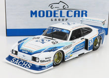Modelo de coche de carreras Ford a escala 1/18 en blanco y azul con las marcas Sachs y Shell, presentado en una caja de Modelcar Group, disponible en Vroomi.