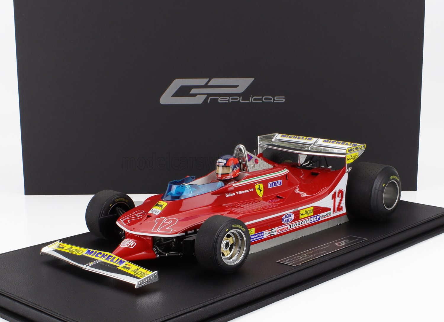 Maqueta de coche de Fórmula 1 Ferrari 312T2 a escala 1:18 con los colores de Gilles Villeneuve, mostrada sobre una base de exposición, vendida en Vroomi.