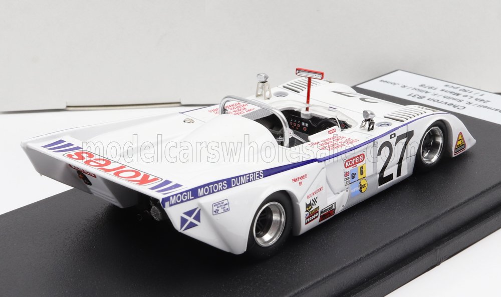 Modelo de coche de carreras vintage blanco número 27 con las marcas Kores y Mogil Motors expuesto sobre una plataforma negra, disponible a través de Vroomi.