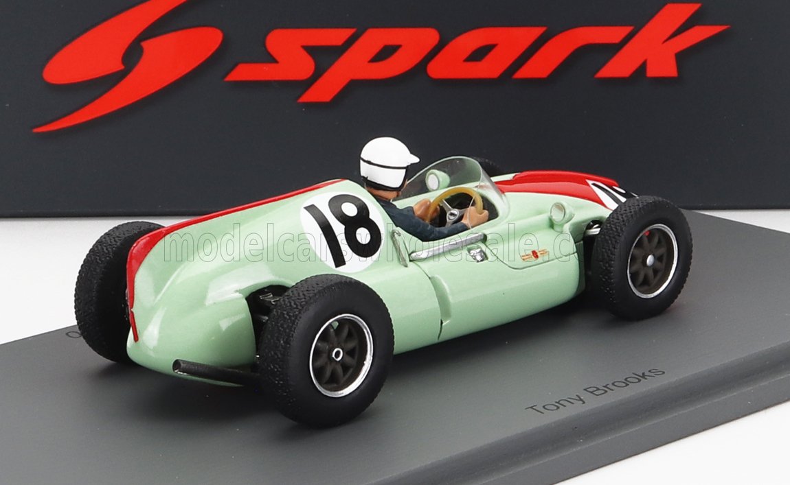 Coche de carreras clásico verde y rojo, modelo número 18, con figura de piloto, expuesto en un soporte, disponible en Vroomi.