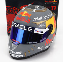 Casco de Fórmula 1 Red Bull gris y amarillo con visera azul y logotipos de patrocinadores, presentado en Vroomi.