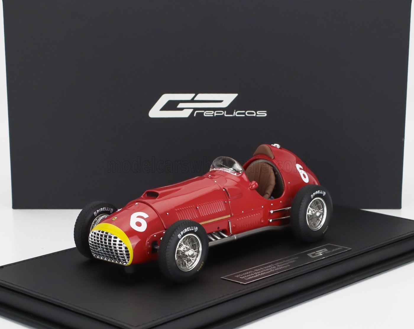 Modelo de coche de carreras GP vintage rojo réplica número 6 en plataforma de exposición, disponible en Vroomi.