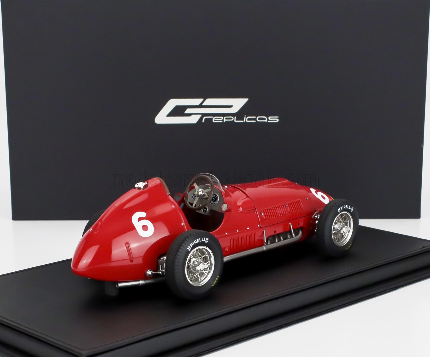 Modelo de coche de carreras vintage rojo con el número 6 sobre una base negra, ofrecido en Vroomi.