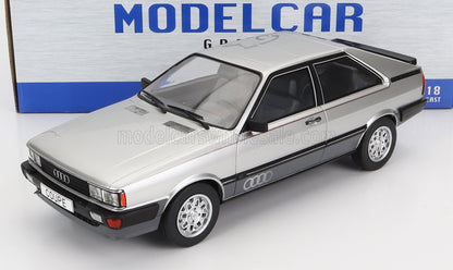 Coupé Audi plateado, modelo a escala 1/18 fabricado en metal fundido a presión, con acabados en negro e interior detallado, disponible en Vroomi.
