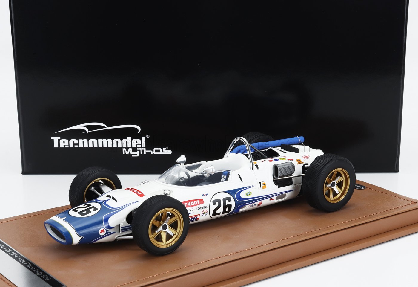 Modelo de coche de carreras vintage blanco y azul a escala 1:18 de Tecnmodel con el número 26 en una vitrina marrón, presentado en Vroomi.