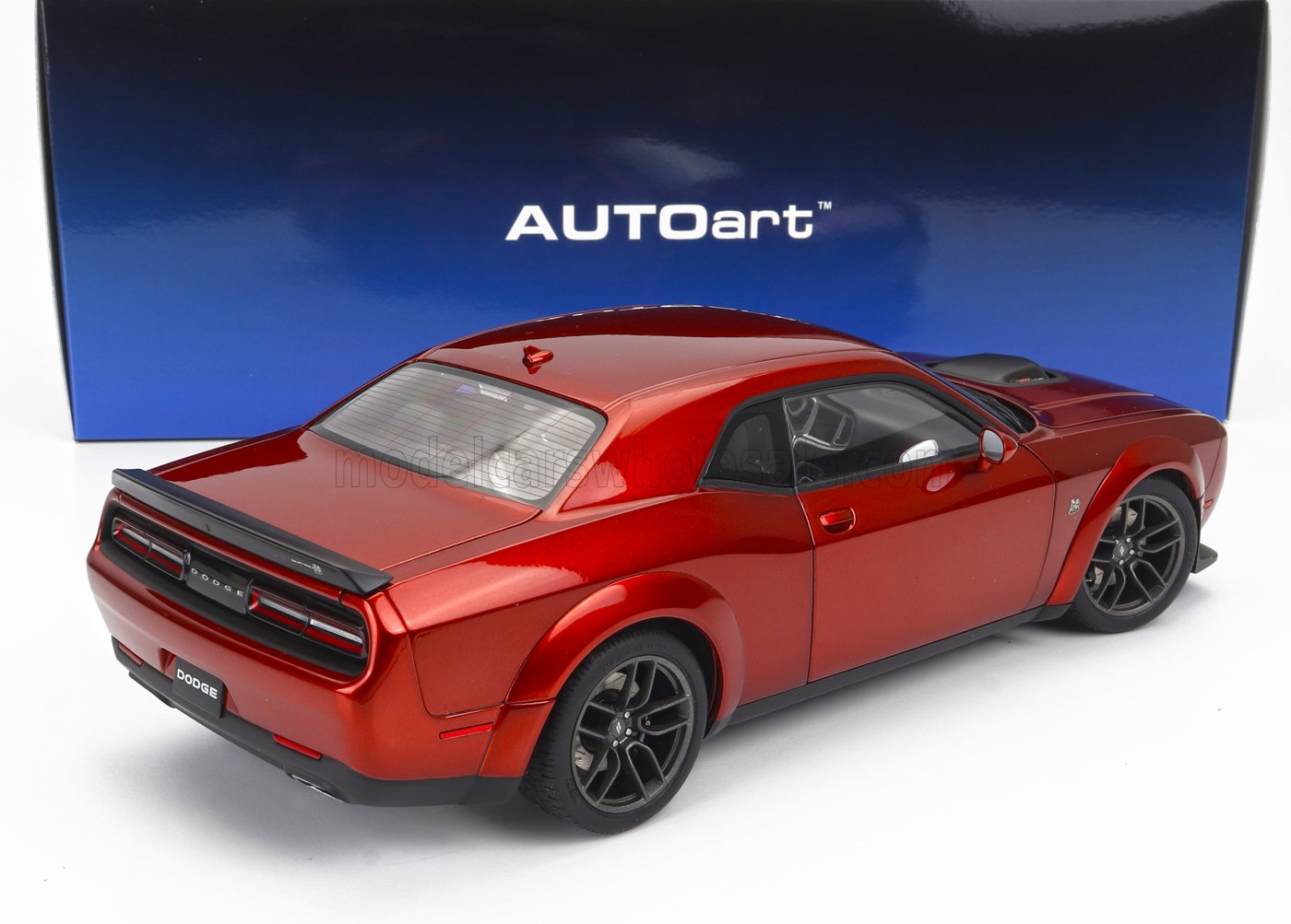 Modelo de coche Dodge Challenger Hellcat rojo de AUTOart expuesto sobre una superficie blanca, disponible en la plataforma Vroomi.