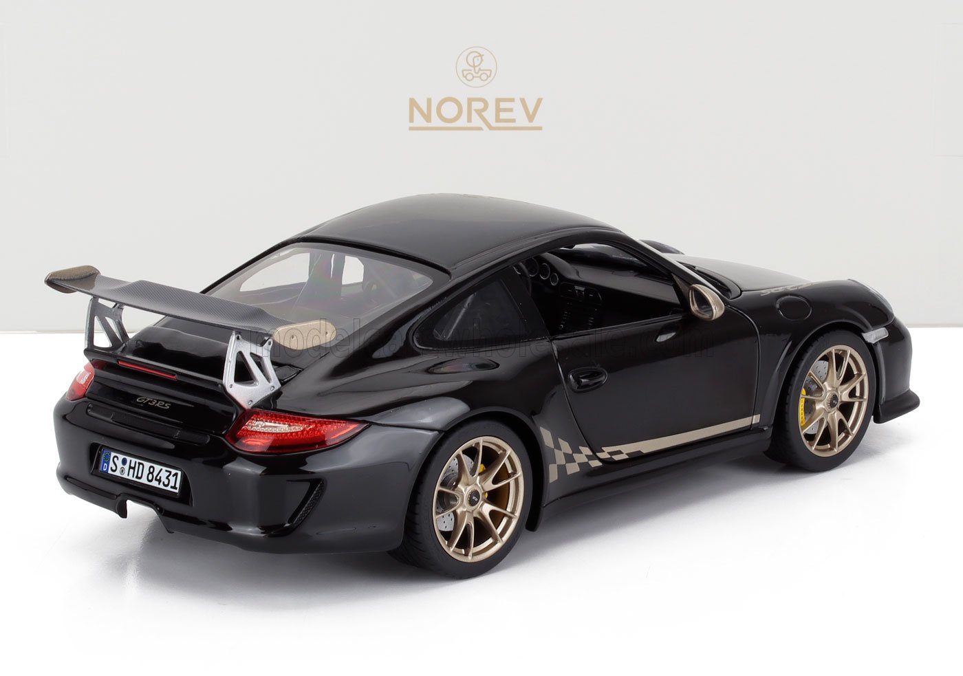 Modelo de coche Porsche 911 GT3 RS negro con llantas doradas y alerón trasero, disponible en la plataforma Vroomi.