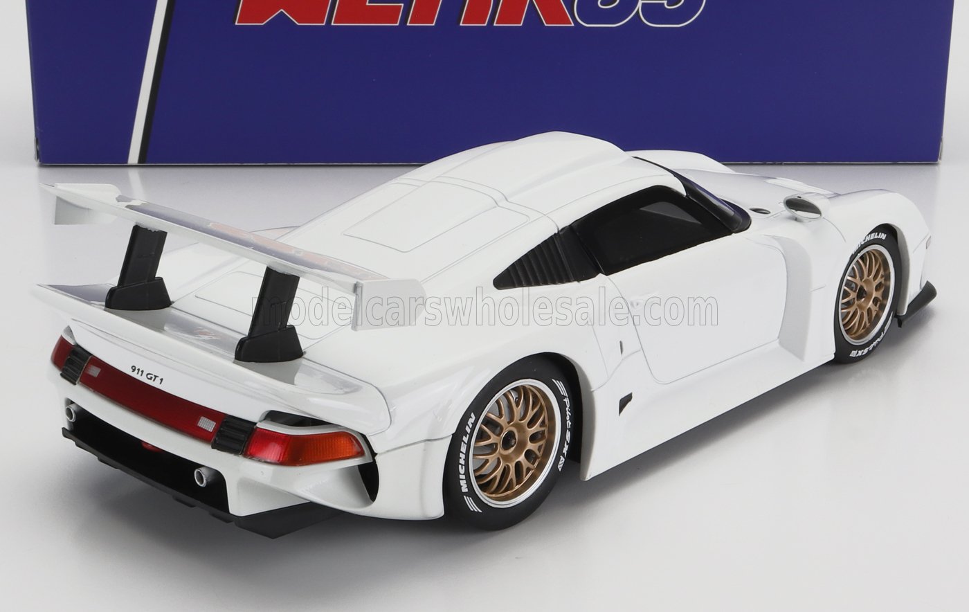 Coche modelo Porsche 911 GT1 blanco con alerón trasero y llantas doradas, disponible en Vroomi.