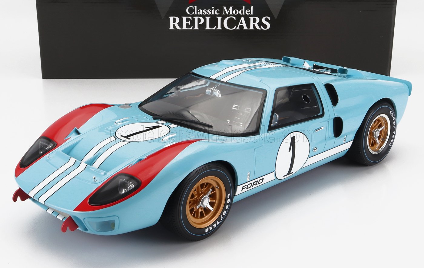 Réplica del modelo clásico Ford GT40 azul claro con franjas rojas y blancas de carreras, llantas doradas, disponible en Vroomi.