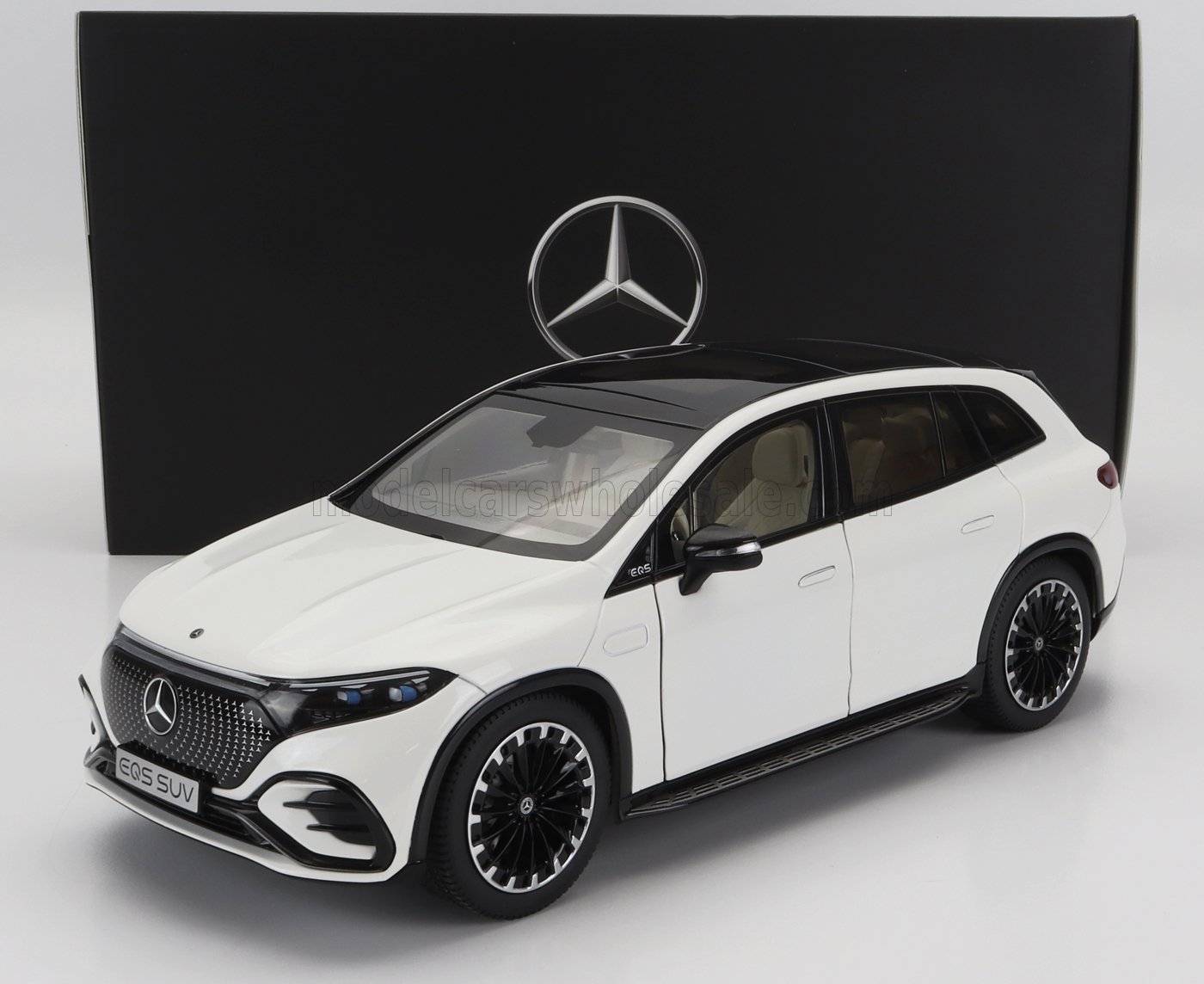 Modelo de coche Mercedes EQS SUV blanco delante de una caja negra con el logotipo de Mercedes, disponible en Vroomi.