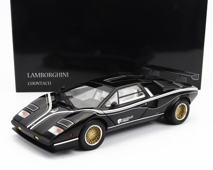 Modelo de coche Lamborghini Countach LP500R negro con llantas doradas, mostrado sobre una caja negra, disponible en Vroomi.