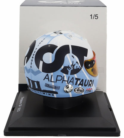 Casco de carreras AlphaTauri con grandes logotipos red bull Honda, visera detallada, en soporte de exposición, disponible en Vroomi.
